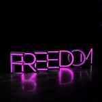 Purple neon letters that spell Freedom.